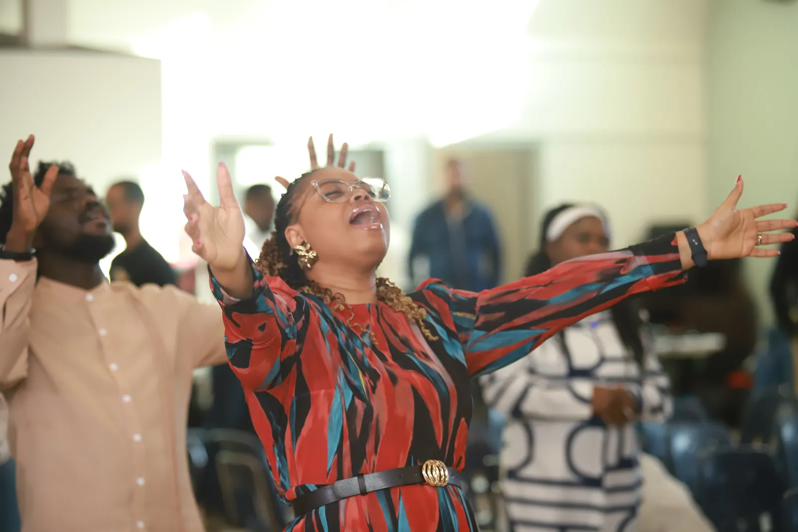 Peace Church Global members worshipping with hands raised